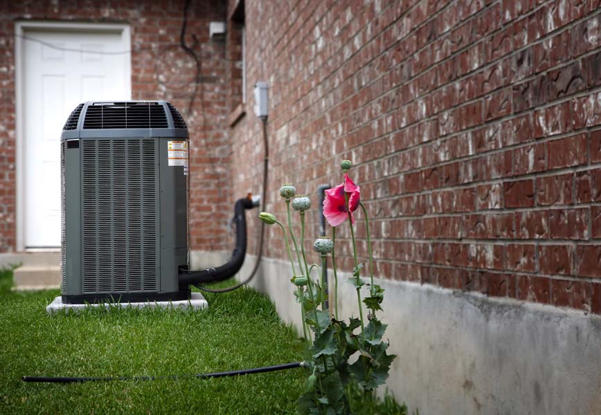 Air conditioner in backyard of home in summer time