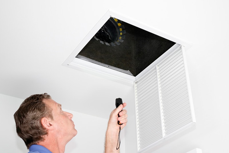 Man looking into air vent