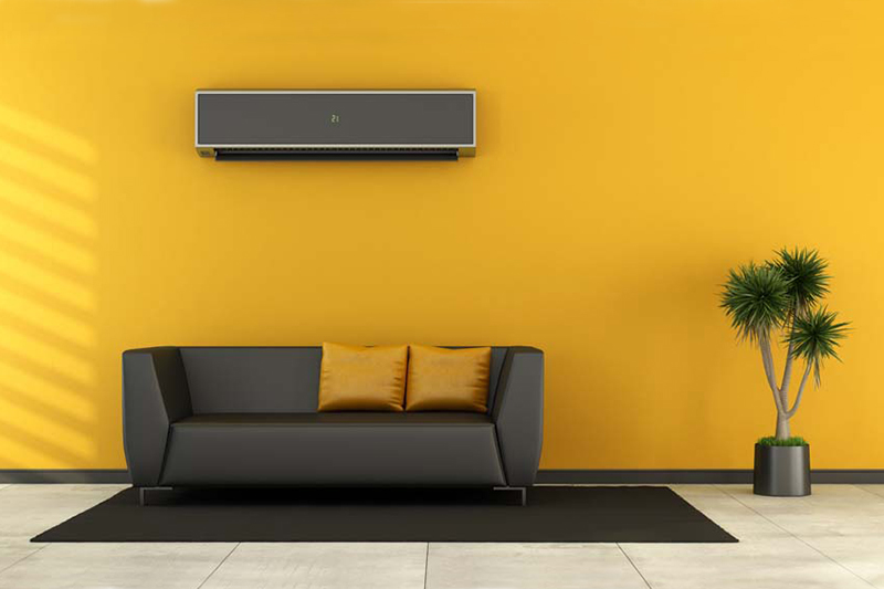 Blog Title: Consider a Ductless AC System Photo: Yellow living room with Ductless AC unit